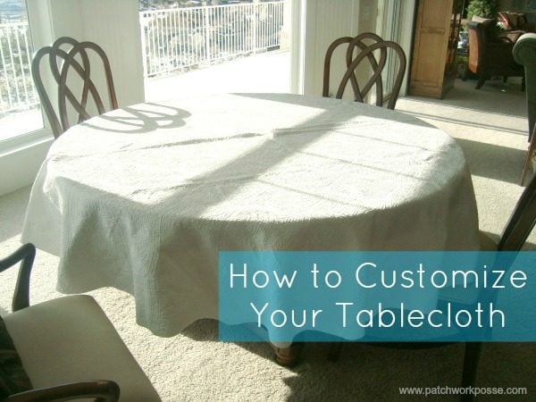 25+ Easy Sewing Projects to Brighten Your Kitchen 12 A round table covered with a white textured tablecloth is surrounded by wooden chairs in a sunlit room. Blue text reads, "How to Customize Your Tablecloth for any occasion.