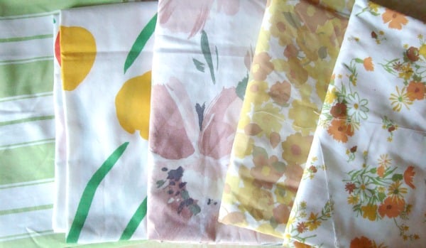 Can You Use Bed Sheets as Quilt Backing? What Quilters Should Know 1 five different vintage sheets that are nicely folded and layered together.