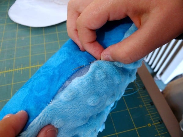 Ladder Stitch for Closing Dolls & Plushies 5 a person sewing a travel pillow using the ladder stitch to close it