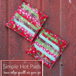 Two colorful quilted hot pads, made with red, green, and white holiday fabrics, rest on a rustic red wooden surface. Featuring a raw edge Quilt As You Go technique, this simple Hot Pad Pattern adds festive charm to any kitchen.