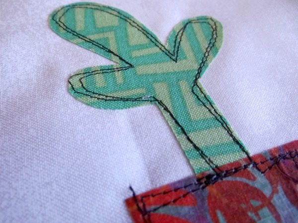 How to Sew a Buttonhole Stitch Around Appliqué (Step-by-Step Tutorial) 6 raw edge applique cactus on a white background fabric with a red pot