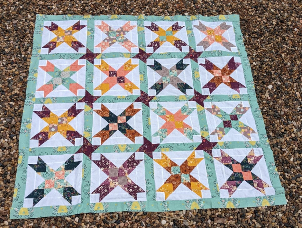 Free Eight Point Star Quilt Pattern 2 eight pointed star laying on the ground that is gravel