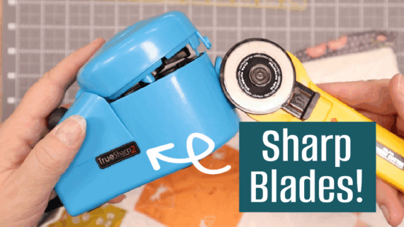 A person holds a blue Rotary Cutter Blade Sharpener and a yellow rotary cutter above colorful fabric, with the text "Sharp Blades!" in a blue box and an arrow pointing to the sharpener. Perfect for any Blade Sharpener Tutorial!.
