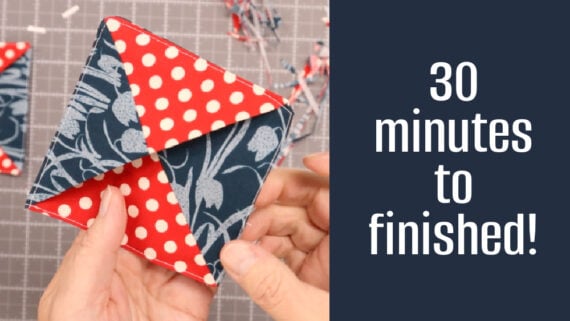 A person holds a folded fabric corner bookmark with red polka dot and blue floral patterns. Text beside reads, "30 minutes to finished!" A cutting mat and fabric scraps are in the background, making this a perfect 30 minute project.