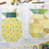 Two pineapple quilt blocks, made from yellow and green fabric pieces, are laid out on a white surface with sewing supplies—perfect if you want to sew pineapple quilt blocks or learn to sew with a free sewing tutorial.