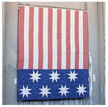 250th Anniversary Pattern Bundle - Limited Time 5 A fabric hangs on a wall, resembling a flag with red patterned vertical stripes, a blue section at the bottom, and six white, eight-pointed stars in a row across the blue area—a striking design from the 250th Anniversary Pattern Bundle.