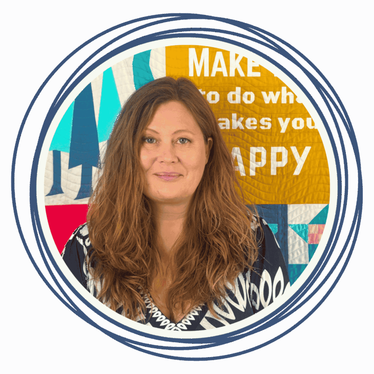 A woman with long, wavy brown hair and a patterned top stands in front of a colorful quilted background with motivational text, hinting at a quilting summit. The image is framed by blue concentric circles.