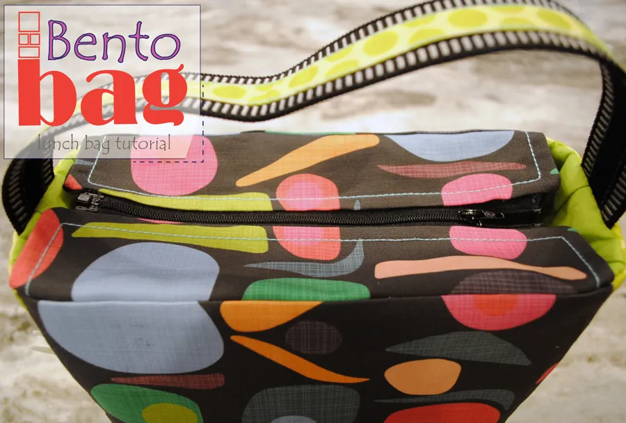 Easy and Cute Lunch Bag Sewing Patterns You'll Want to Make and Use 9 A colorful fabric bento bag with a zipper and patterned strap, placed on a light surface. The overlay text reads "Bento bag lunch bag tutorial." Perfect for anyone looking for cute lunch bag ideas or easy lunch bag projects, this tutorial is inspired by popular lunch bag sewing patterns.