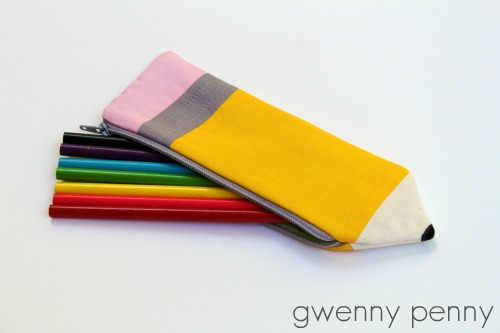 A pencil-shaped zippered pouch contains six colored markers (green, blue, black, yellow, red, and pink) on a white background. Perfect for those who love to make their own accessories, this Pencil pouch is a fun project idea inspired by sewing patterns. The words "gwenny penny" appear in the bottom right corner.