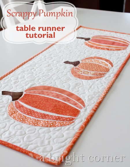 Fall Appliqué Patterns That Are Perfect for Your Fabric Scraps 10 Quilted table runner featuring three orange pumpkins on a white background, bordered in vibrant orange fabric. Showcasing a charming fall applique design, the text reads “Scrappy Pumpkin table runner tutorial” and “a bright corner” in the corner.