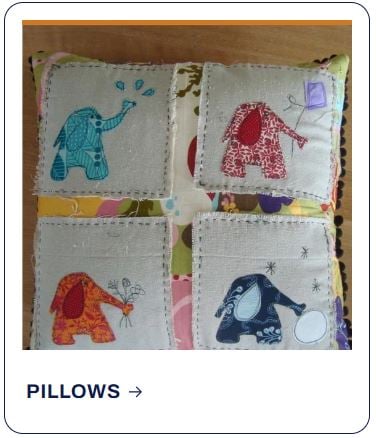 A decorative pillow featuring four stitched squares, each depicting an elephant with a unique applique and simple embroidered scene, crafted with the intricate detail of shop patterns.